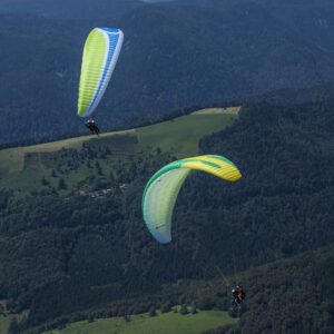Deux parapentes biplace en vol thermique au-dessus des Vosges – activité de loisir aérien en Alsace