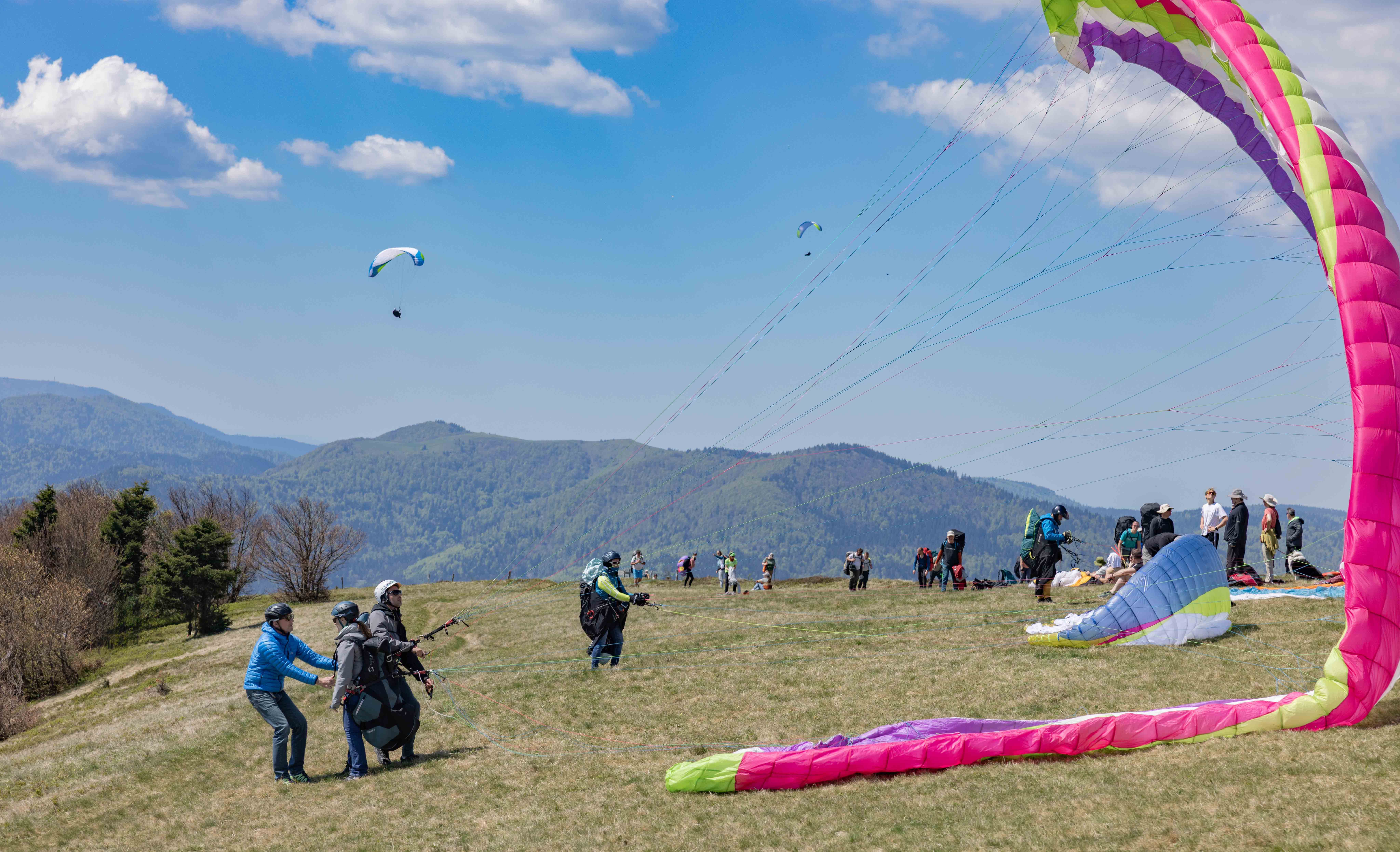 Décollage parapente biplace au Treh dans les Vosges, en Alsace, avec vue sur les montagnes